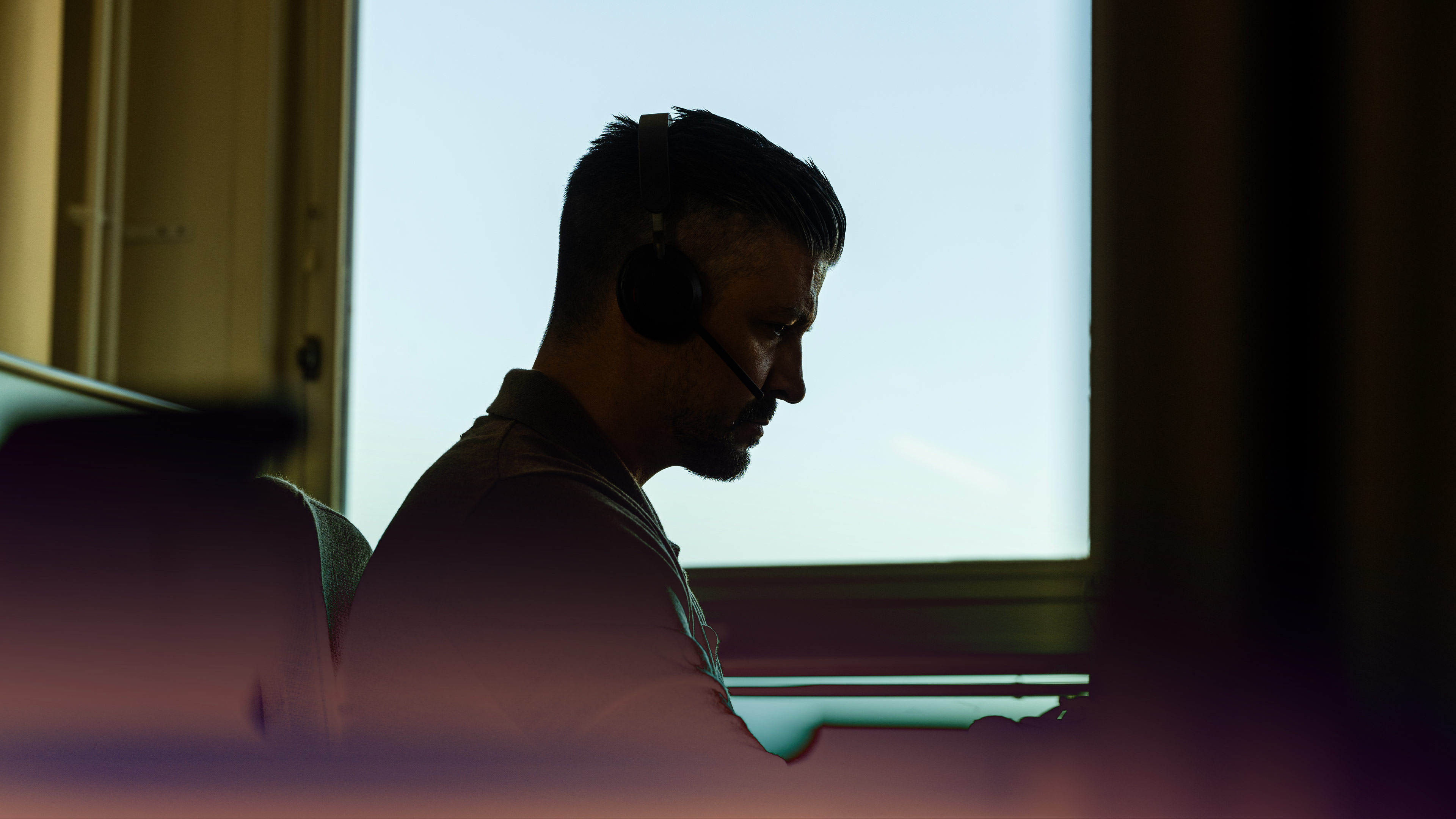 The silhouette of a man with a headset